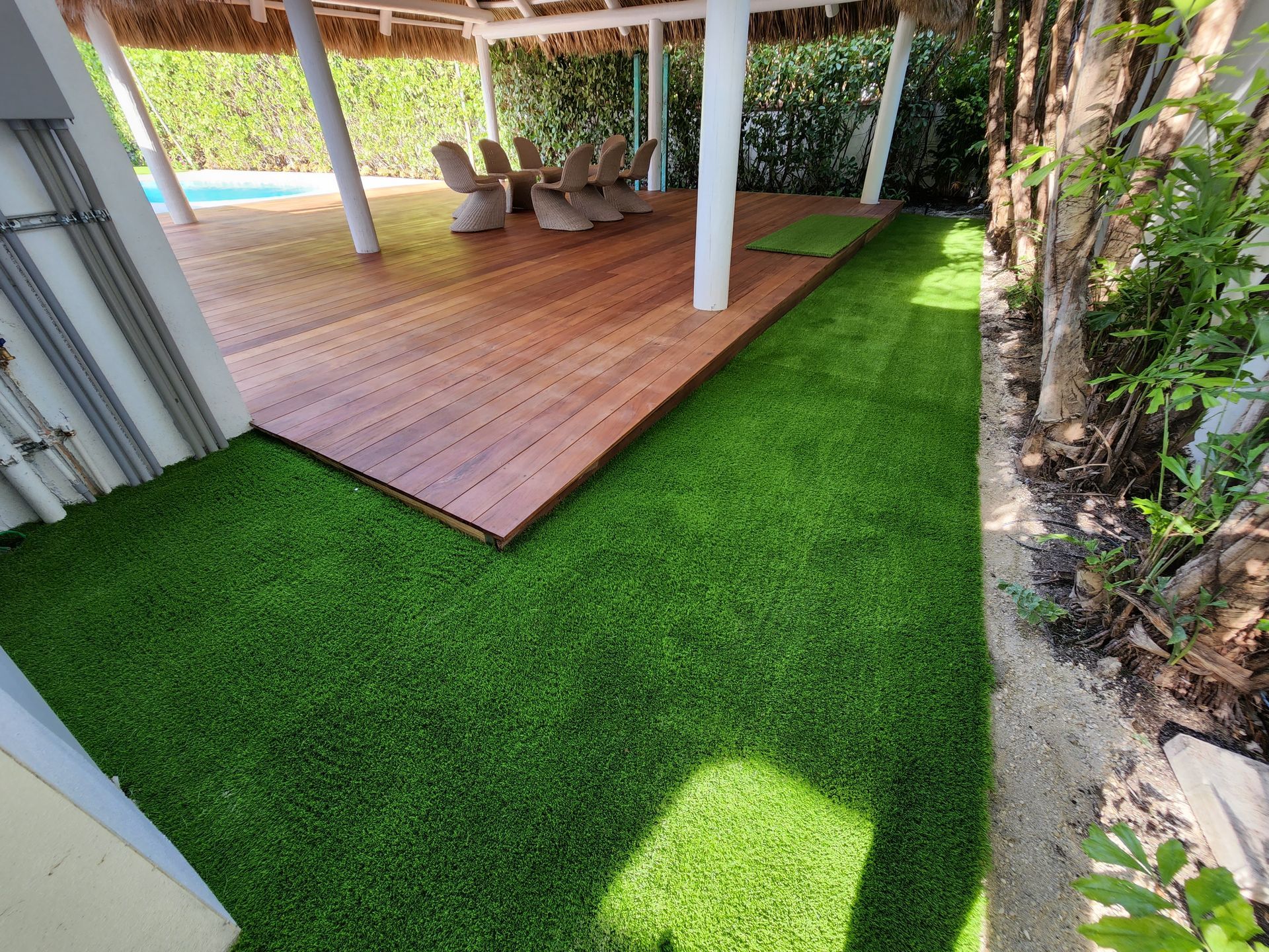 A lush green lawn with a wooden deck in the background.