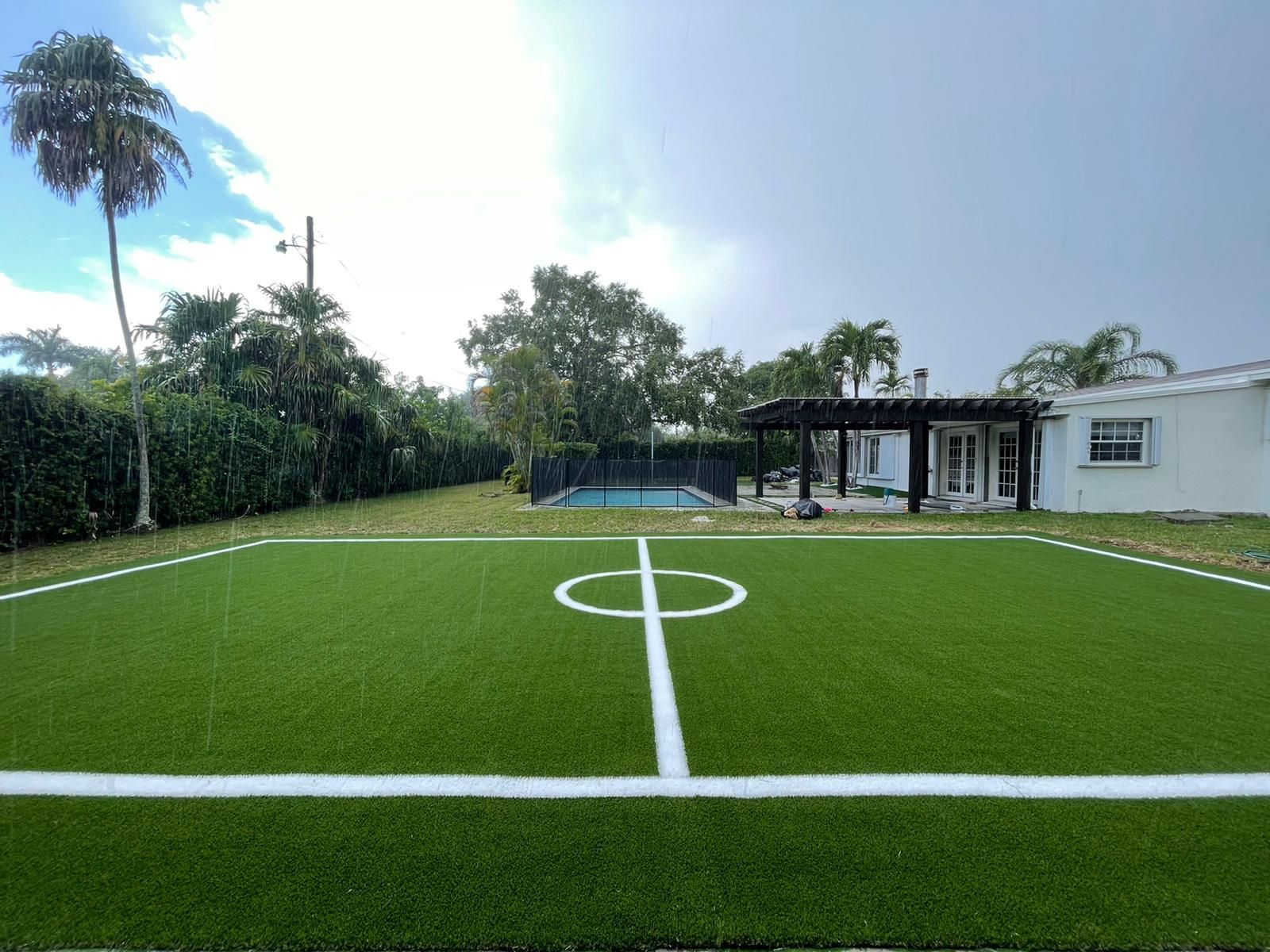 There is a soccer field in the backyard of a house.