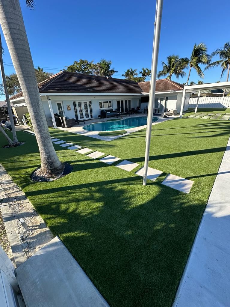 A house with a large lawn and a pool in the backyard.