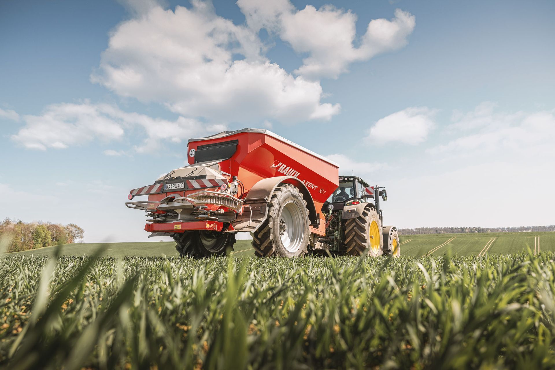 Eine Luftaufnahme eines Traktors, der ein Feld mit einer Sprühanlage besprüht.