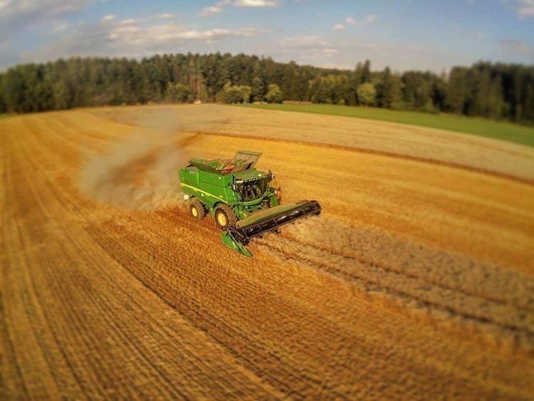 Eine Luftaufnahme eines Mähdreschers bei der Arbeit auf einem Feld.