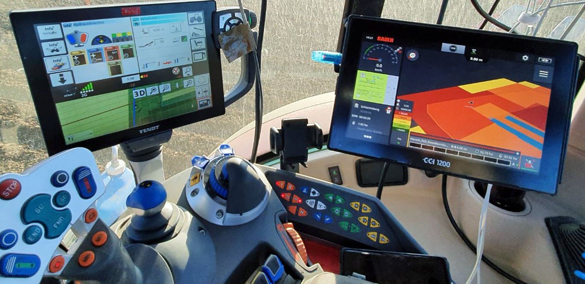 Das Armaturenbrett eines Traktors mit zwei Monitoren darauf.