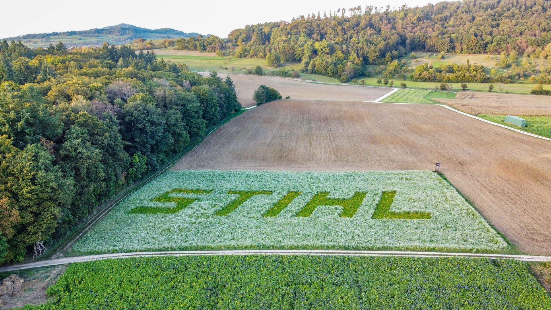 Vor einem Gebäude parkt ein Lastwagen mit einer Maschine auf der Ladefläche.
