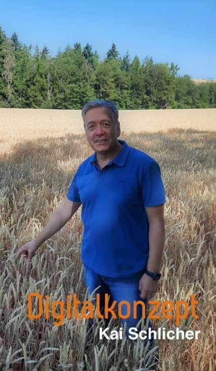 Ein Mann in einem blauen Hemd steht in einem Weizenfeld.