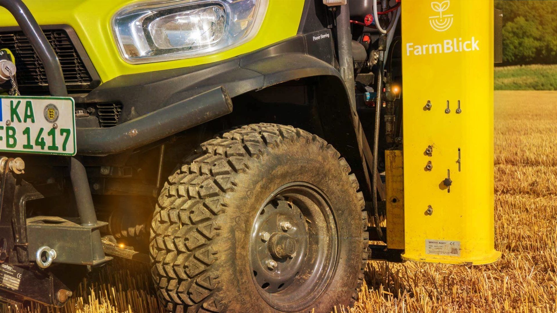 Ein Traktor steht auf einem Feld neben einer gelben Säule.