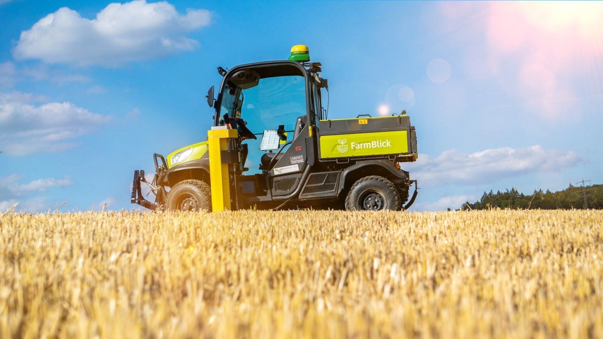 Ein Traktor fährt durch ein Weizenfeld.
