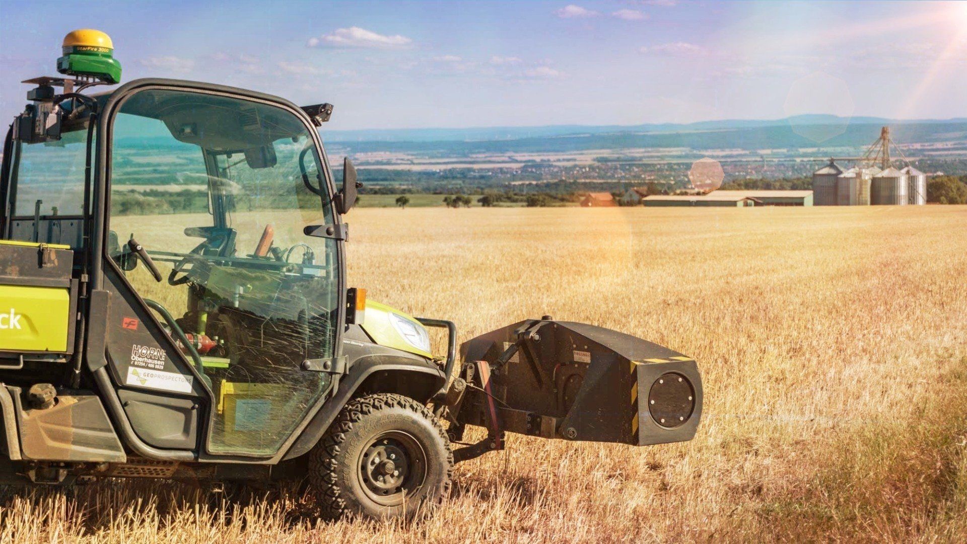 Ein Traktor fährt durch ein Weizenfeld.