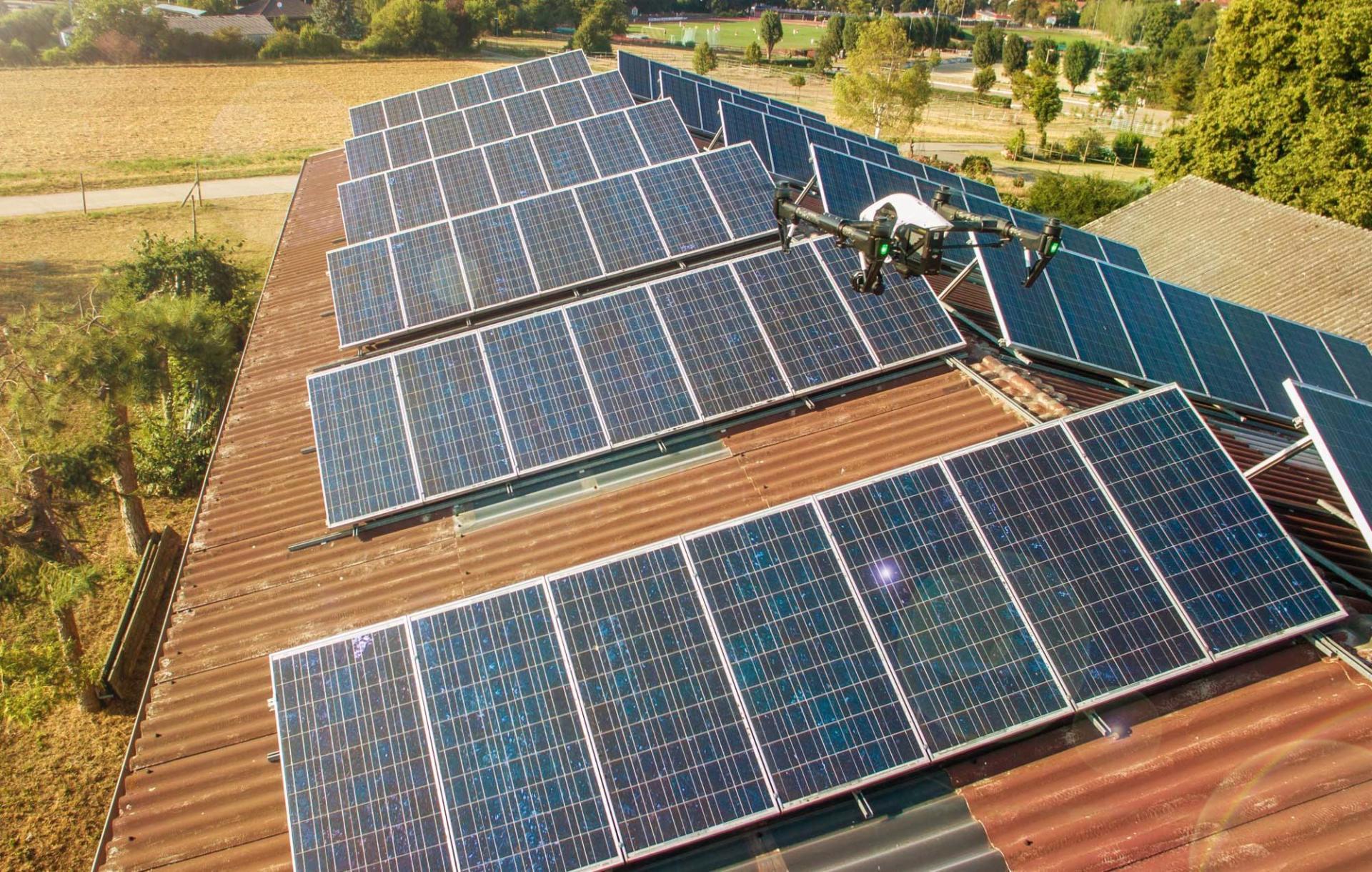 Eine Luftaufnahme eines Daches mit Solarmodulen und einer Drohne.