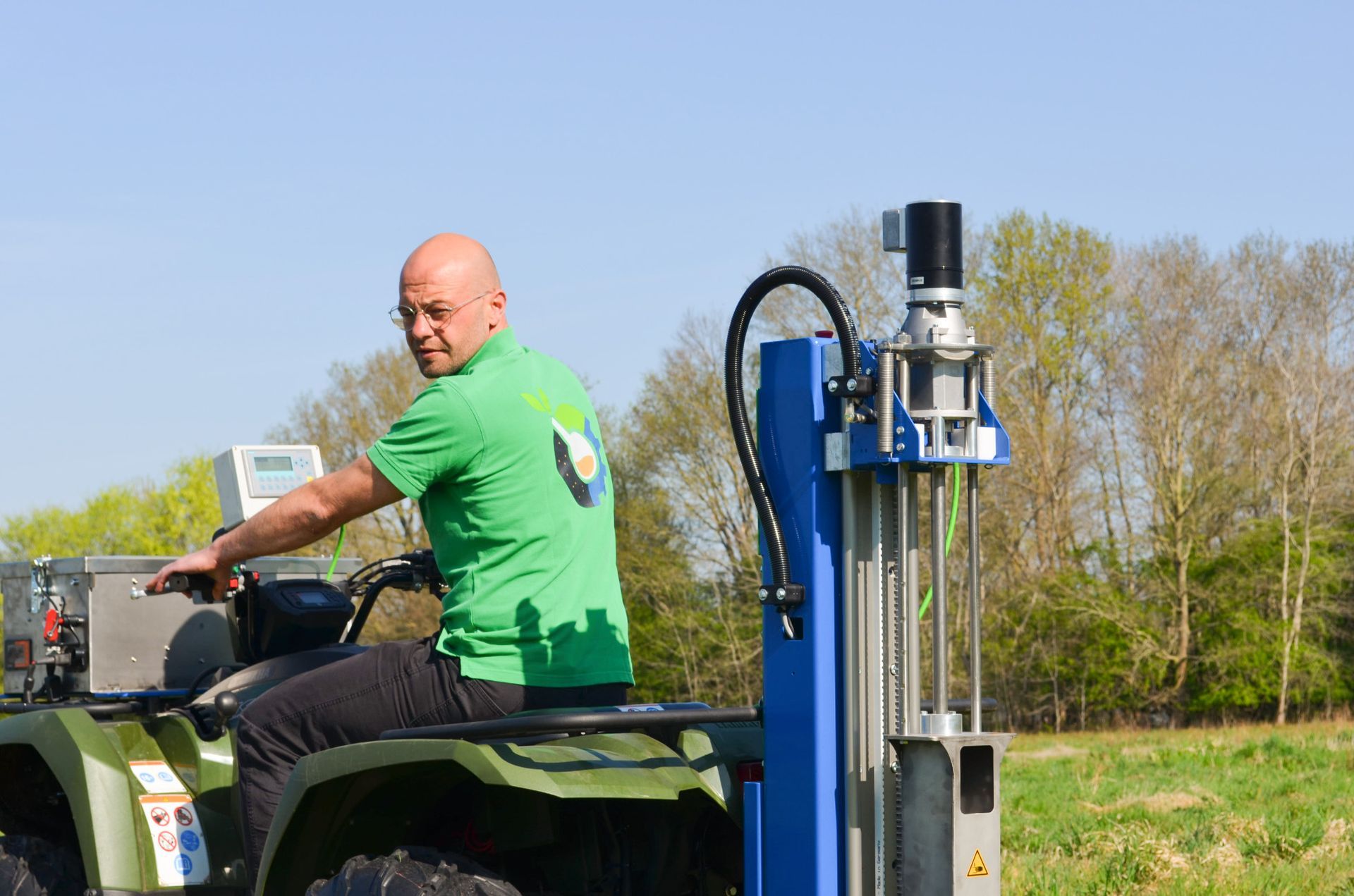 Ein Mann sitzt auf einem Quad auf einem Feld.
