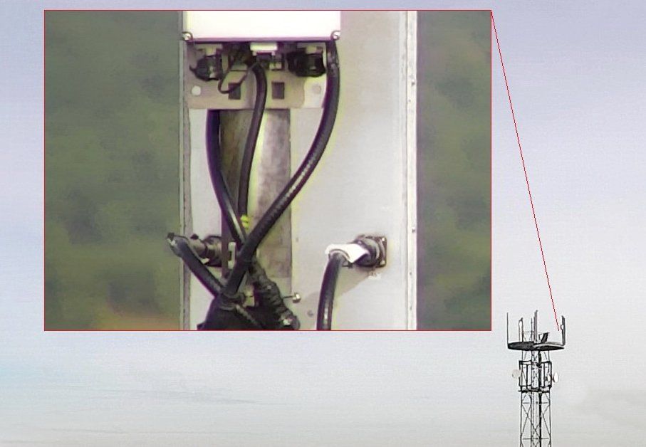 Ein Bild von einem Telefonmast mit einem Turm im Hintergrund