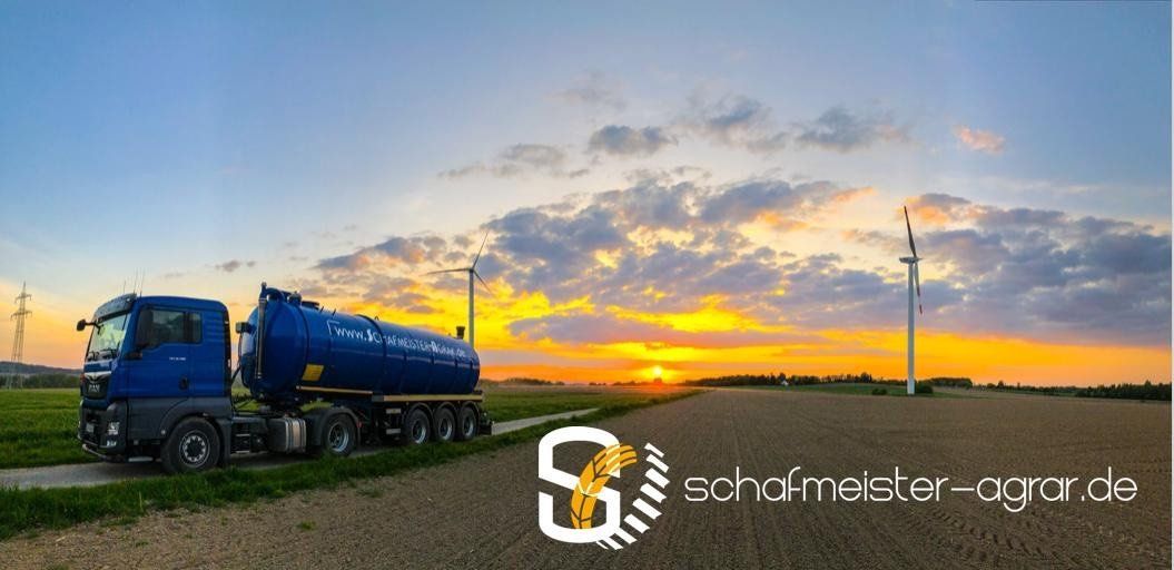 Bei Sonnenuntergang parkt ein blauer Lastwagen auf einem Feld.