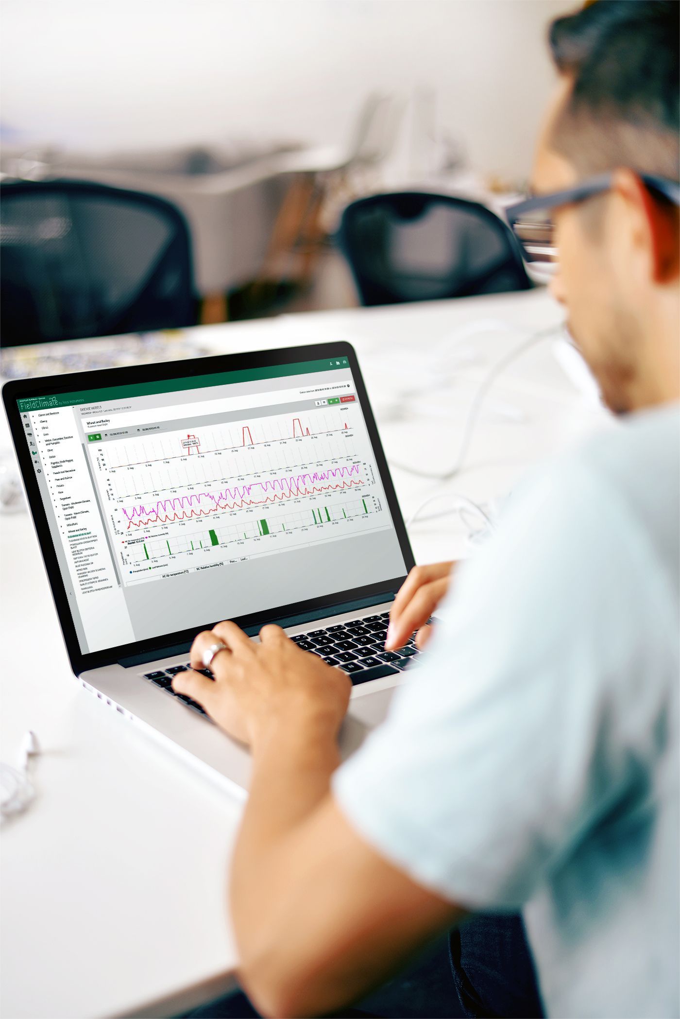 Eine Person, die einen Laptop benutzt und Daten analysiert, ist von hinten zu sehen.