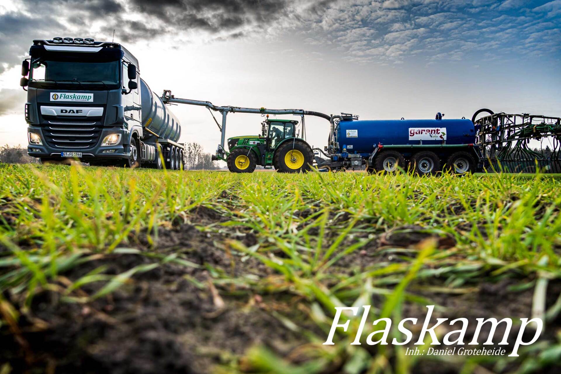 Ein Lastwagen und ein Traktor sind auf einer Wiese geparkt.