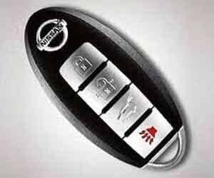 Un primer plano de un control remoto de Nissan sobre una superficie blanca.