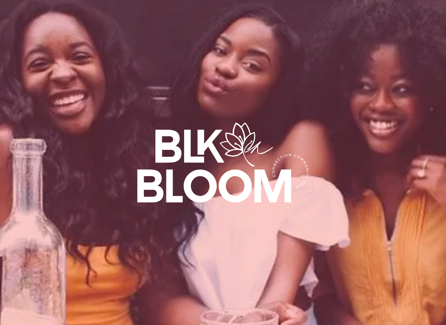 Three women are posing for a picture in front of a sign that says blk bloom