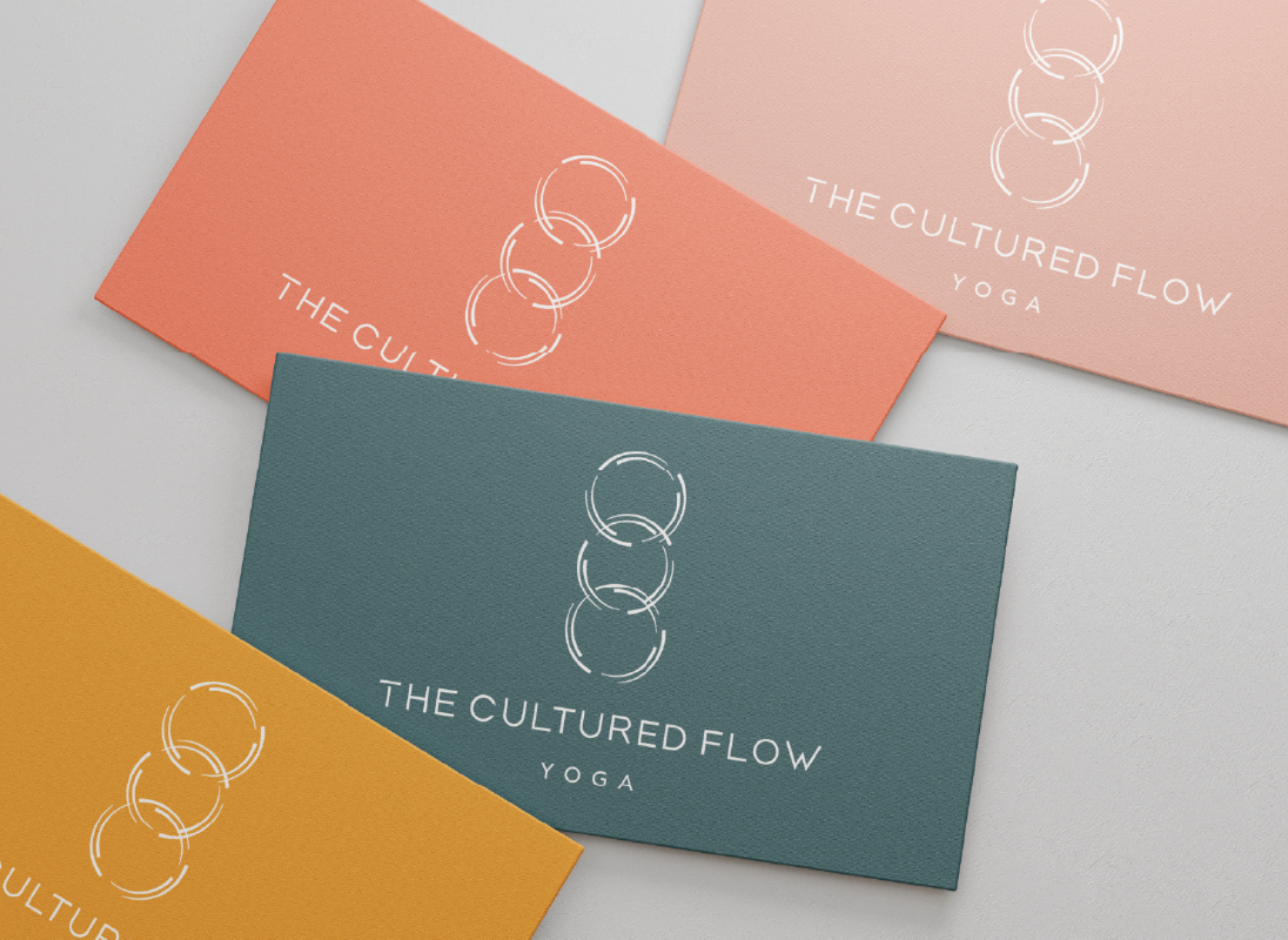 Four business cards for the cultured flow yoga are stacked on top of each other