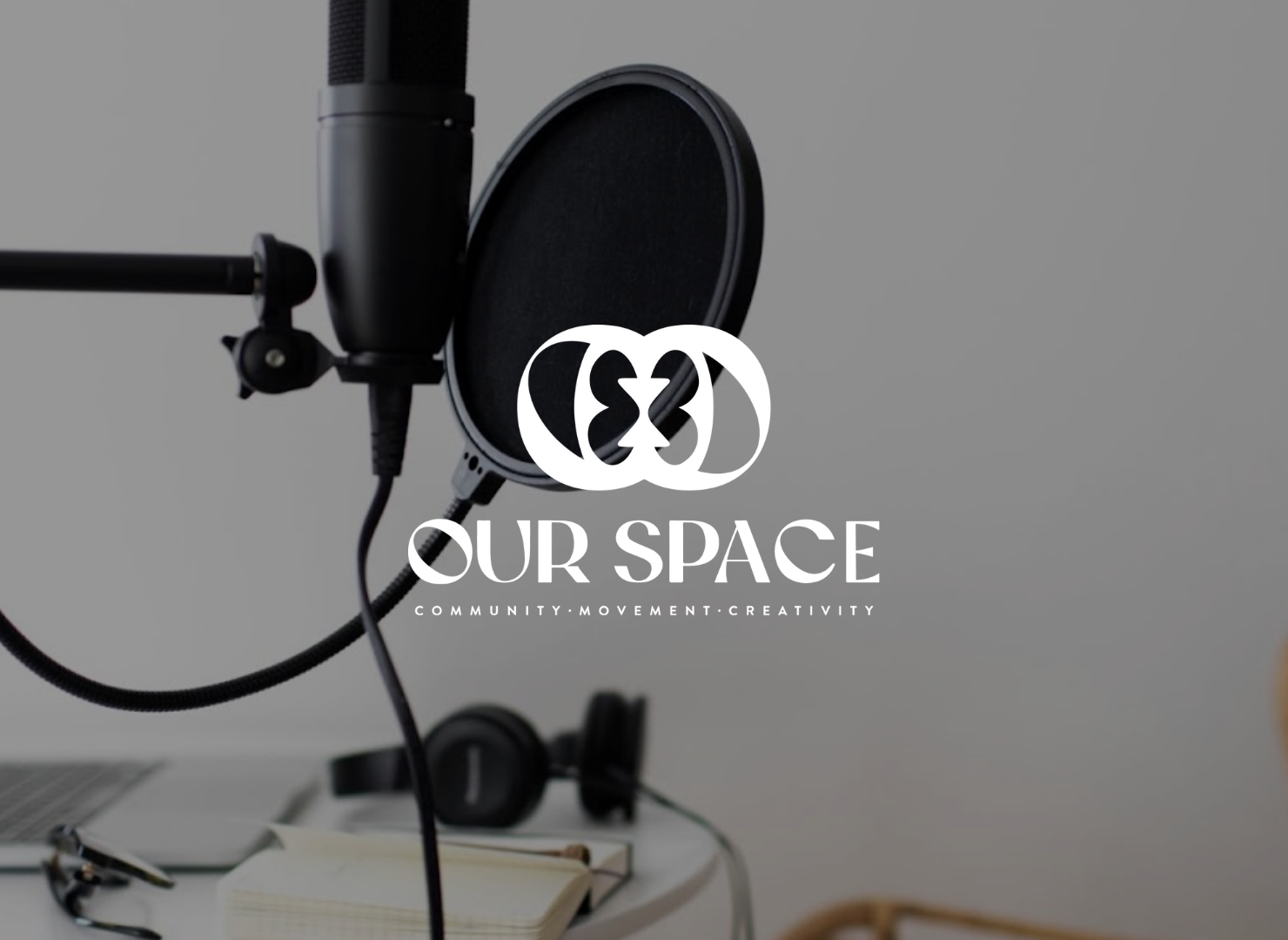 A microphone and headphones on a table with the words our space on the bottom