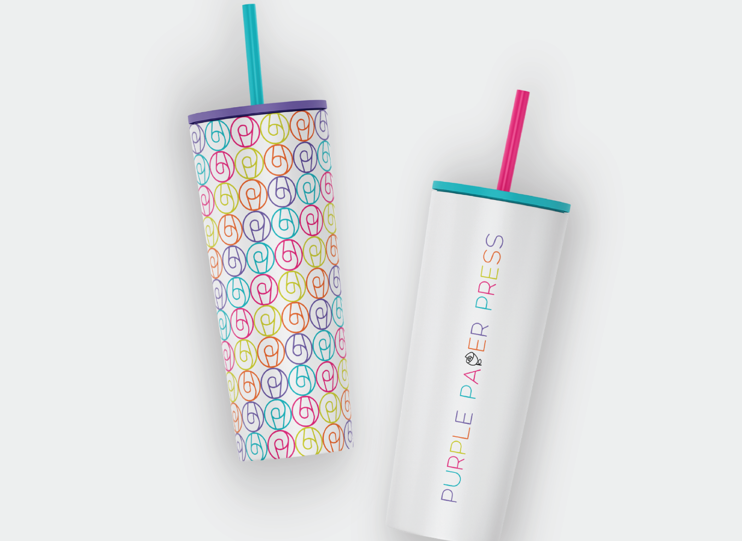 Two stainless steel tumblers with straws on a white surface.