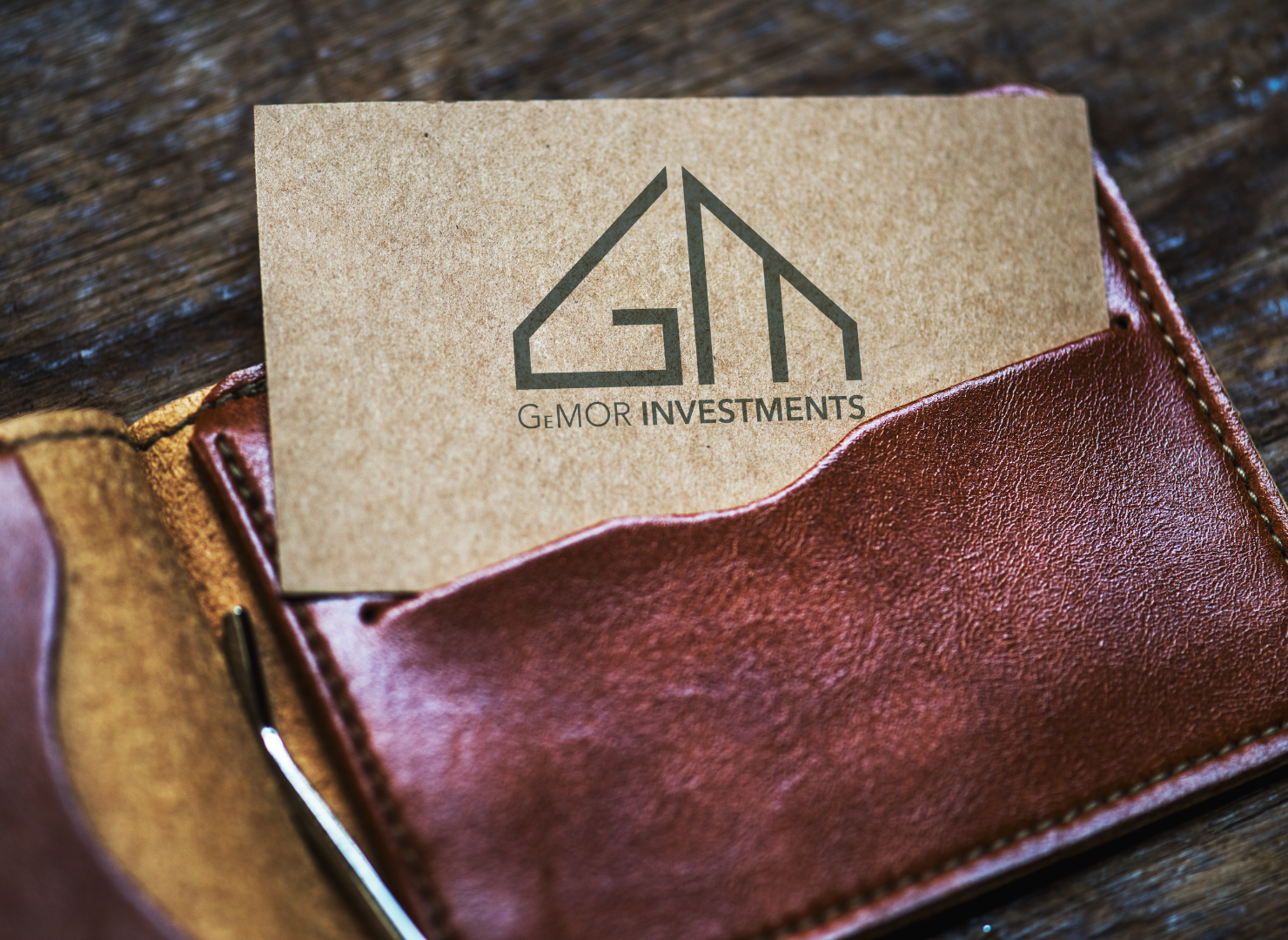 A brown leather wallet with a business card in it.