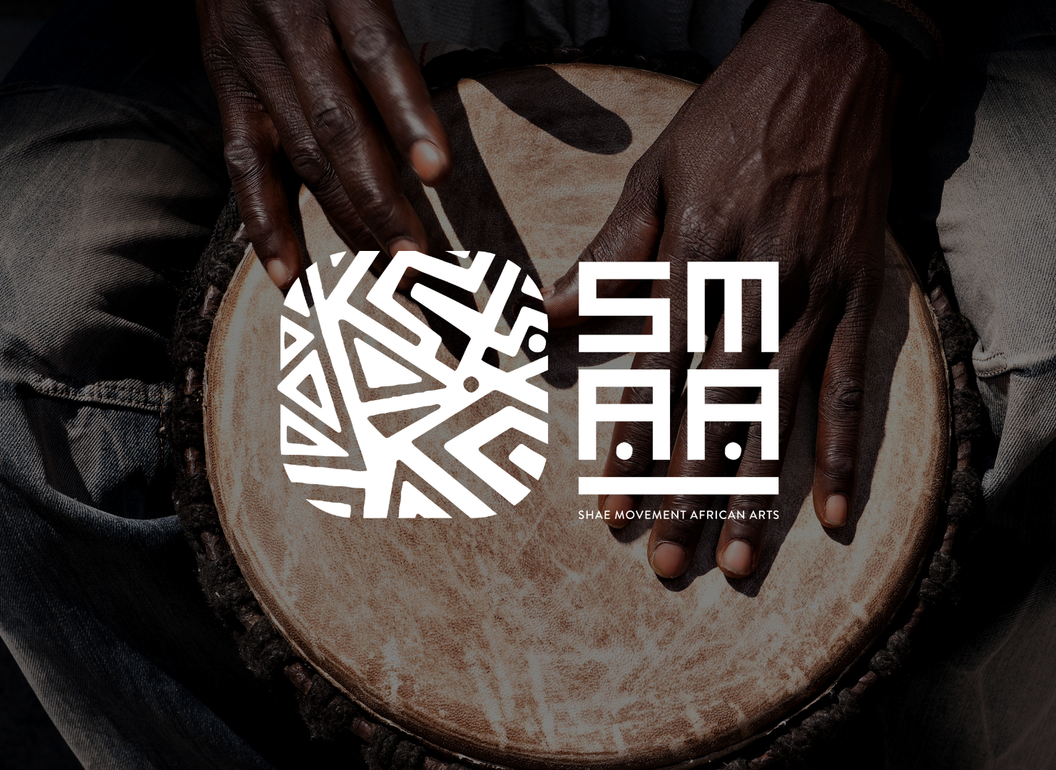 A person is playing a drum with their hands.