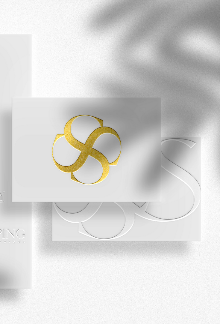 A white business card with a gold logo on it.