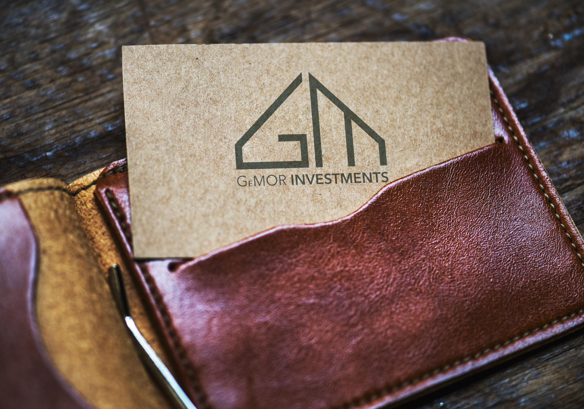 A brown leather wallet with a business card in it.