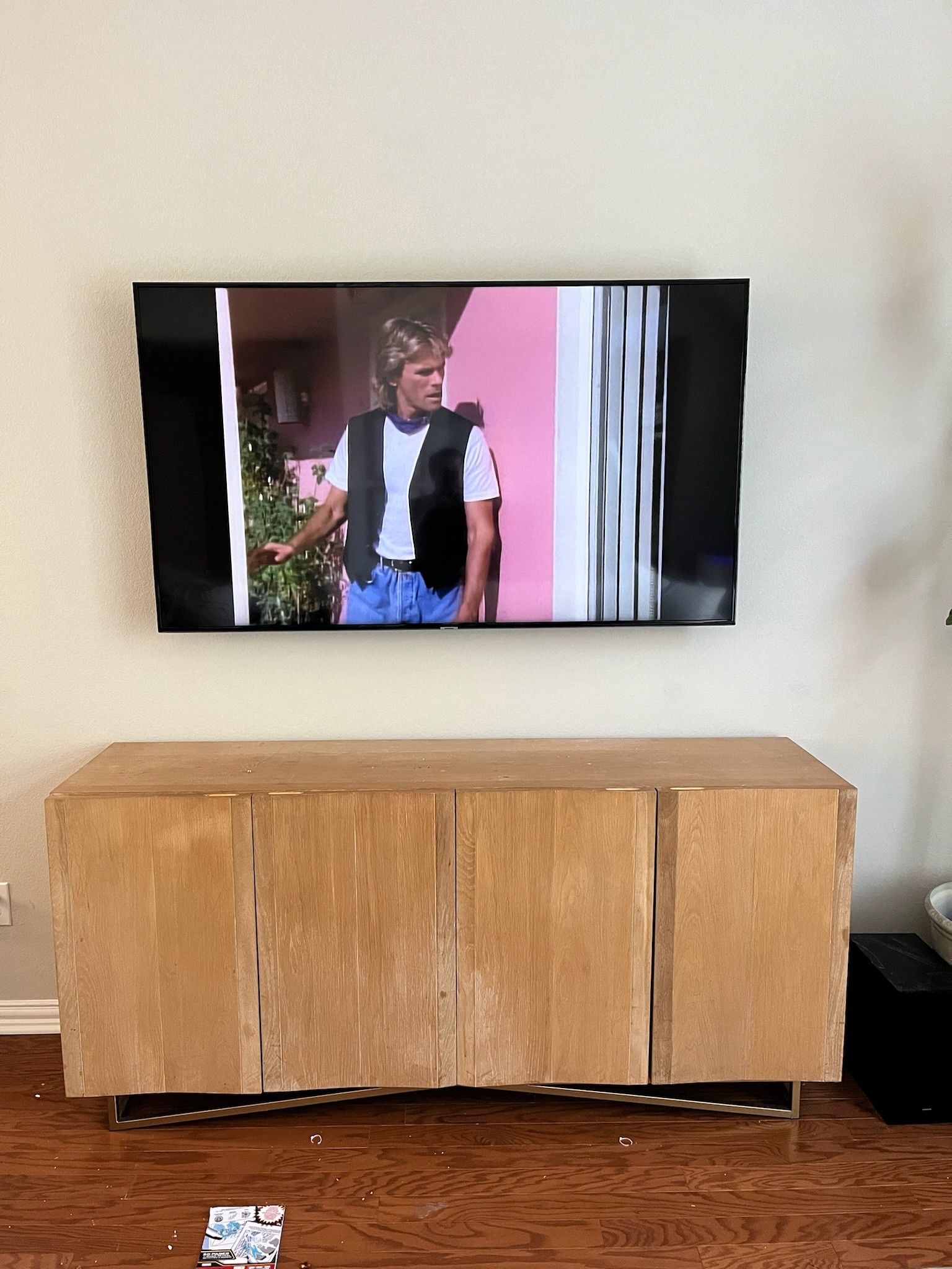 A flat screen tv is hanging on a wall above a wooden entertainment center