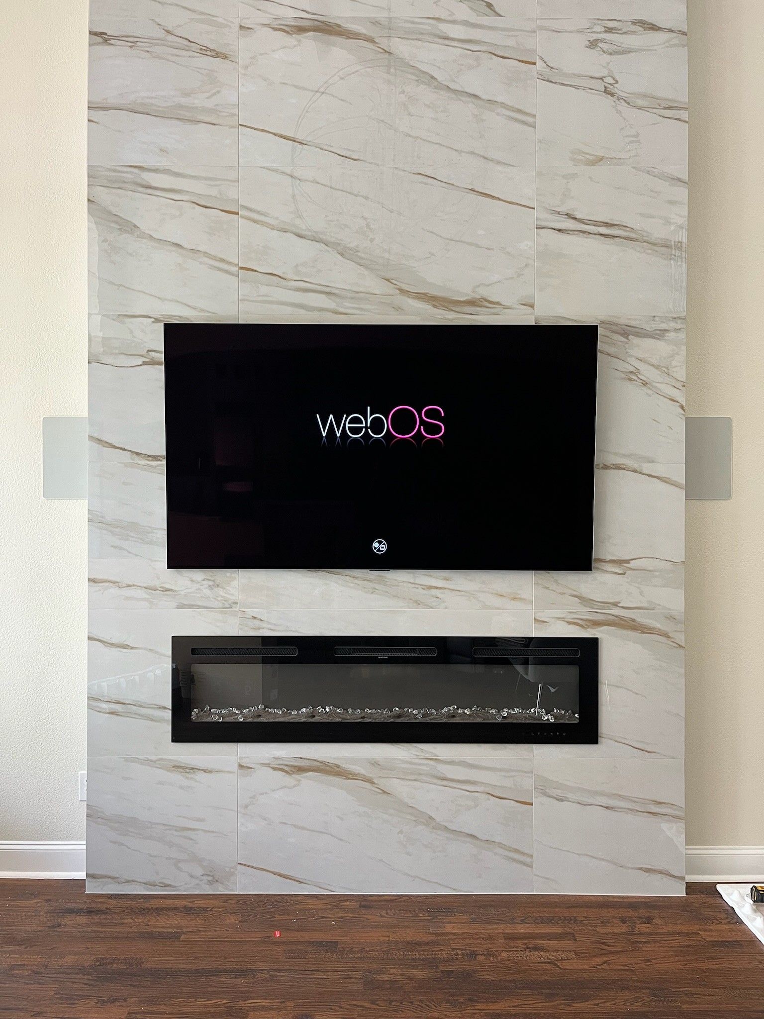 A flat screen tv is mounted on a wall above a fireplace