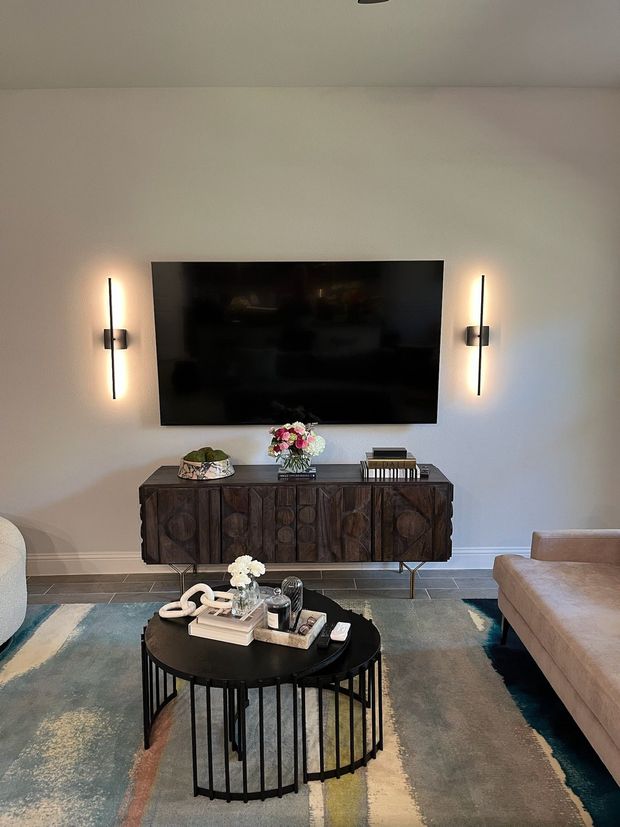 A living room with a flat screen tv on the wall and a coffee table.