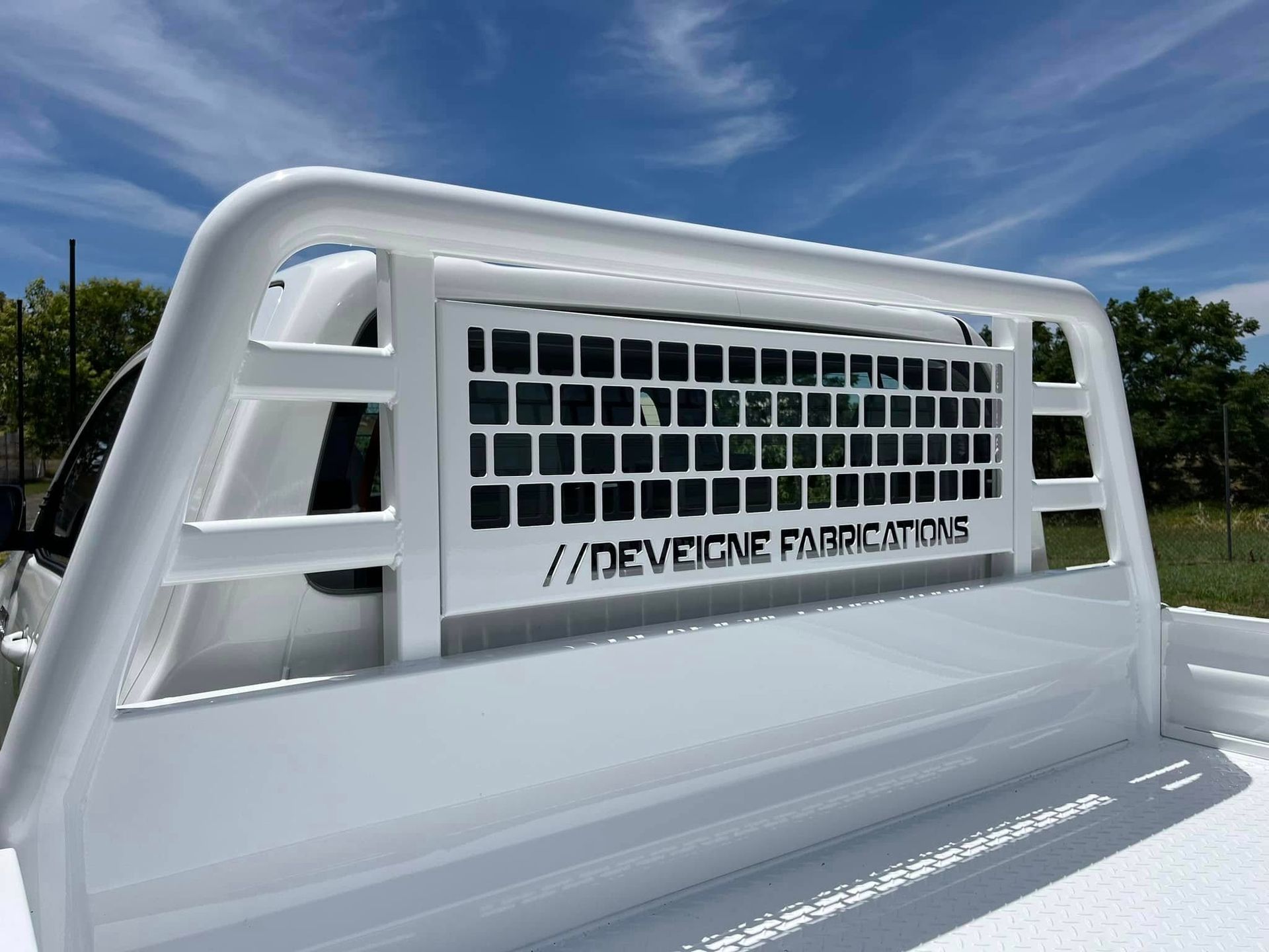 A white ute with business name stencilled into work on tray — Deveigne Fabrications In Brocklehurst, NSW