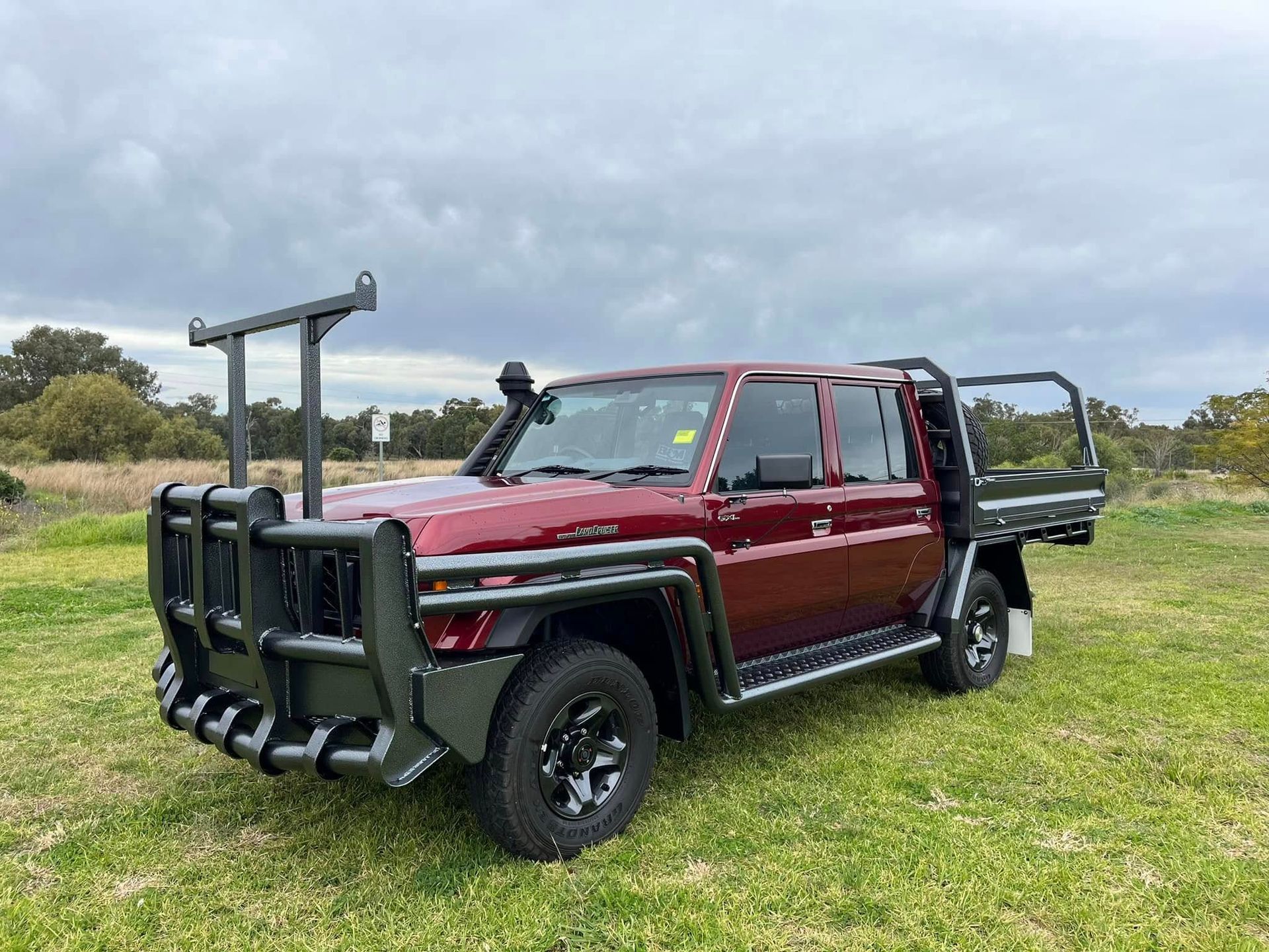 A Black Truck is Parked in the Grass on a Sunny Day — Deveigne Fabrications In Brocklehurst, NSW