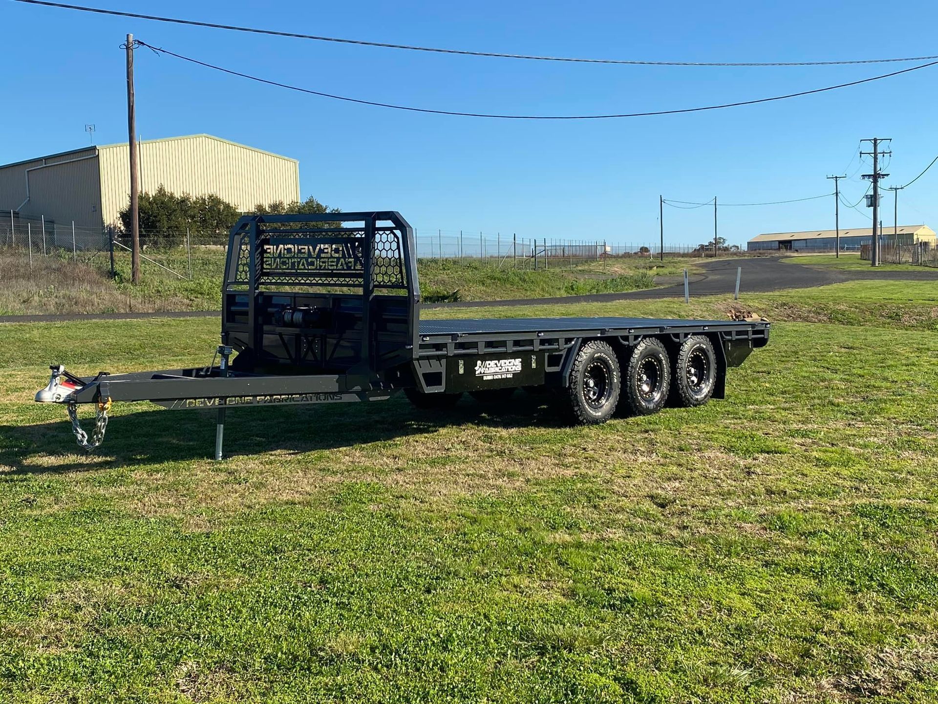A Red Trailer is Parked on Gravel in Front of a Building — Deveigne Fabrications In Brocklehurst, NSW