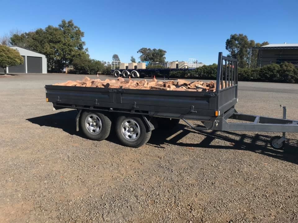 A Truck With a Trailer Attached to It is Parked in a Grassy Field — Deveigne Fabrications In Brocklehurst, NSW