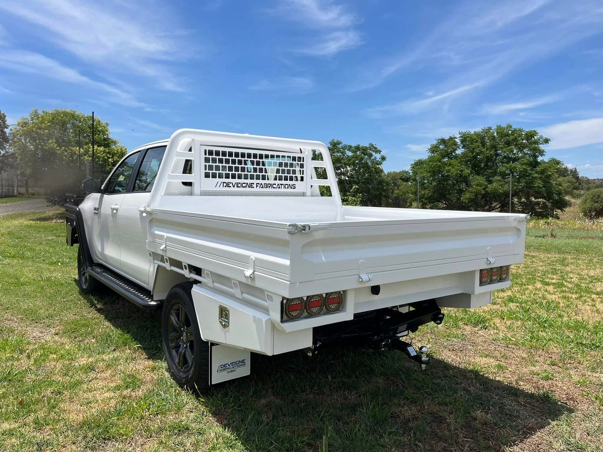 A Truck With a Flat Bed is Parked in the Grass — Deveigne Fabrications In Brocklehurst, NSW