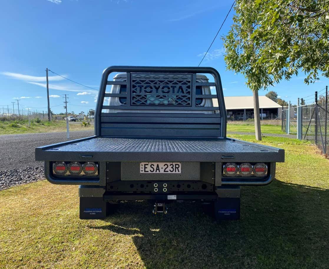 The Back of a Toyota Truck is Parked in the Grass — Deveigne Fabrications In Brocklehurst, NSW