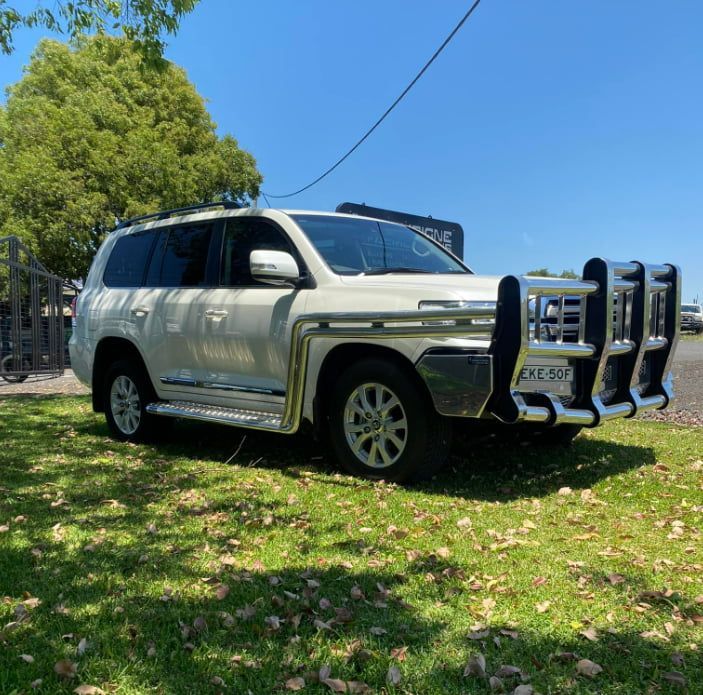 A White Suv With a Chrome Bumper is Parked in the Grass — Deveigne Fabrications In Brocklehurst, NSW