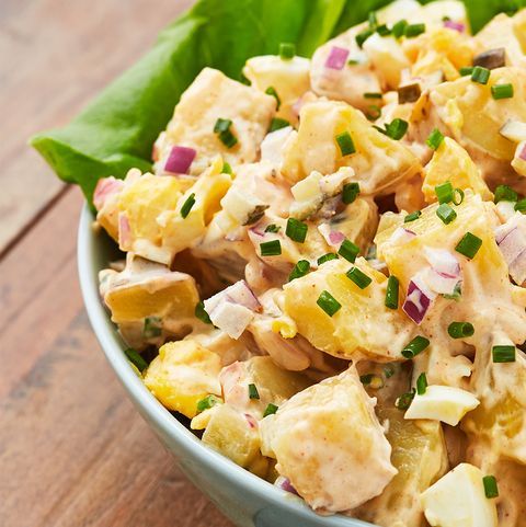A close up of a bowl of potato salad on a table.
