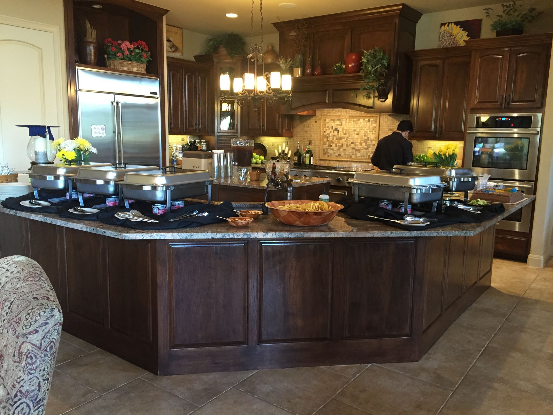 A kitchen with a large island filled with buffet trays