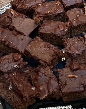 A tray of chocolate brownies with nuts on top