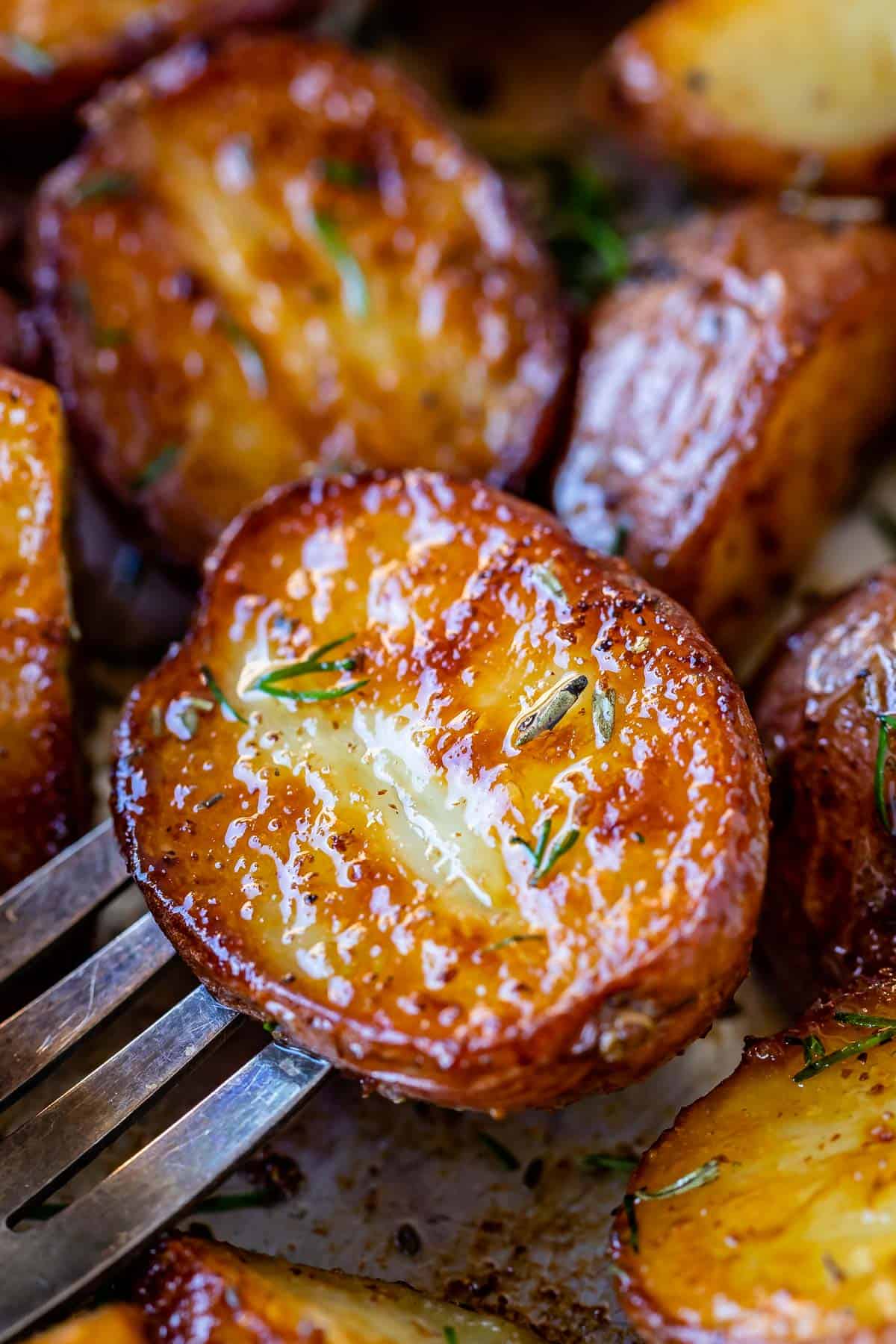 A close up of roasted potatoes on a fork.