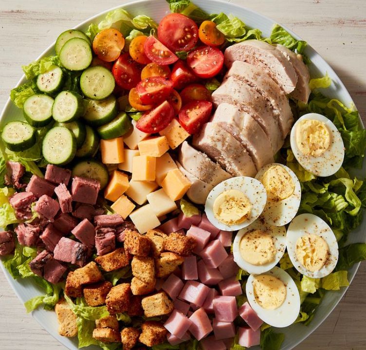 A white plate topped with a variety of meats and vegetables