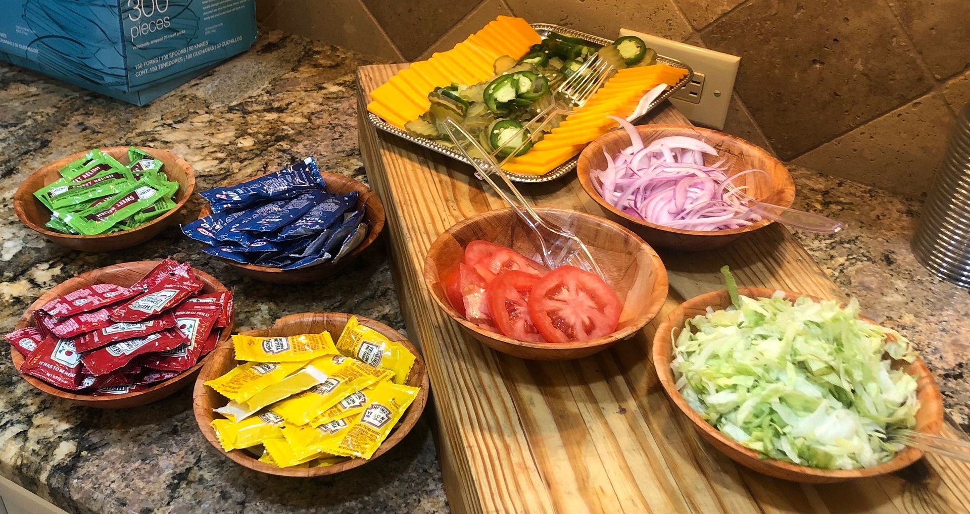 A wooden table topped with bowls of vegetables and condiments.
