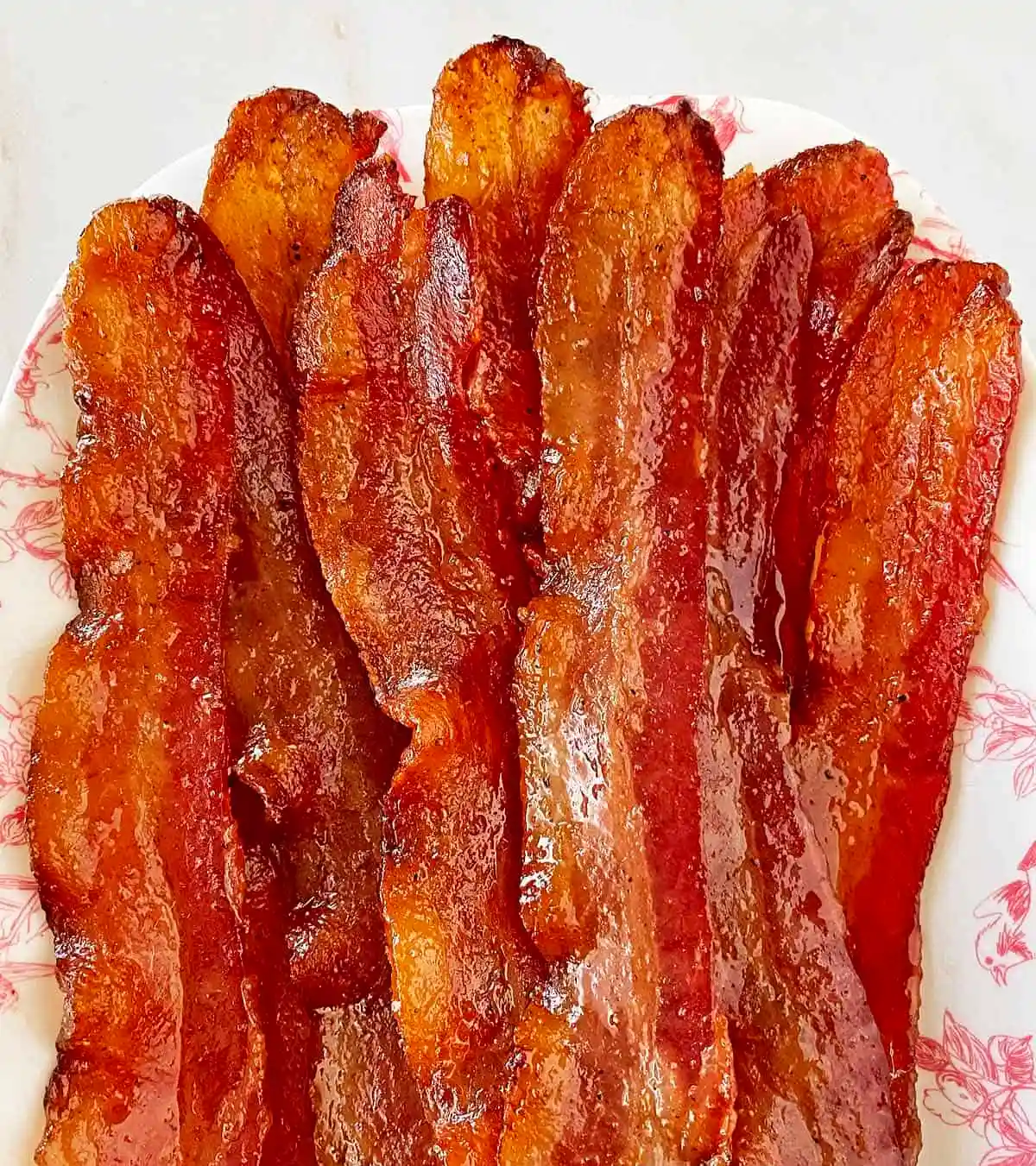 A close up of a plate of bacon on a table.