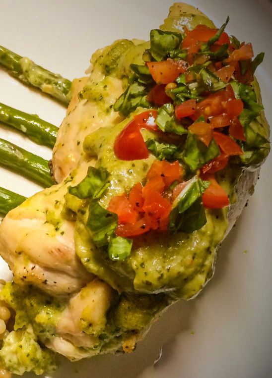 A close up of a plate of food with chicken and green beans on a table.