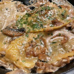 A close up of a pan of food with mushrooms and cheese.