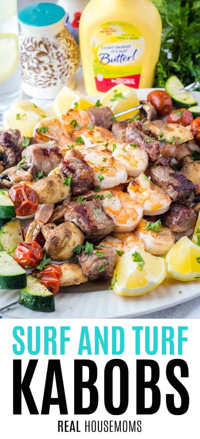 A plate of surf and turf kabobs with vegetables on a table.