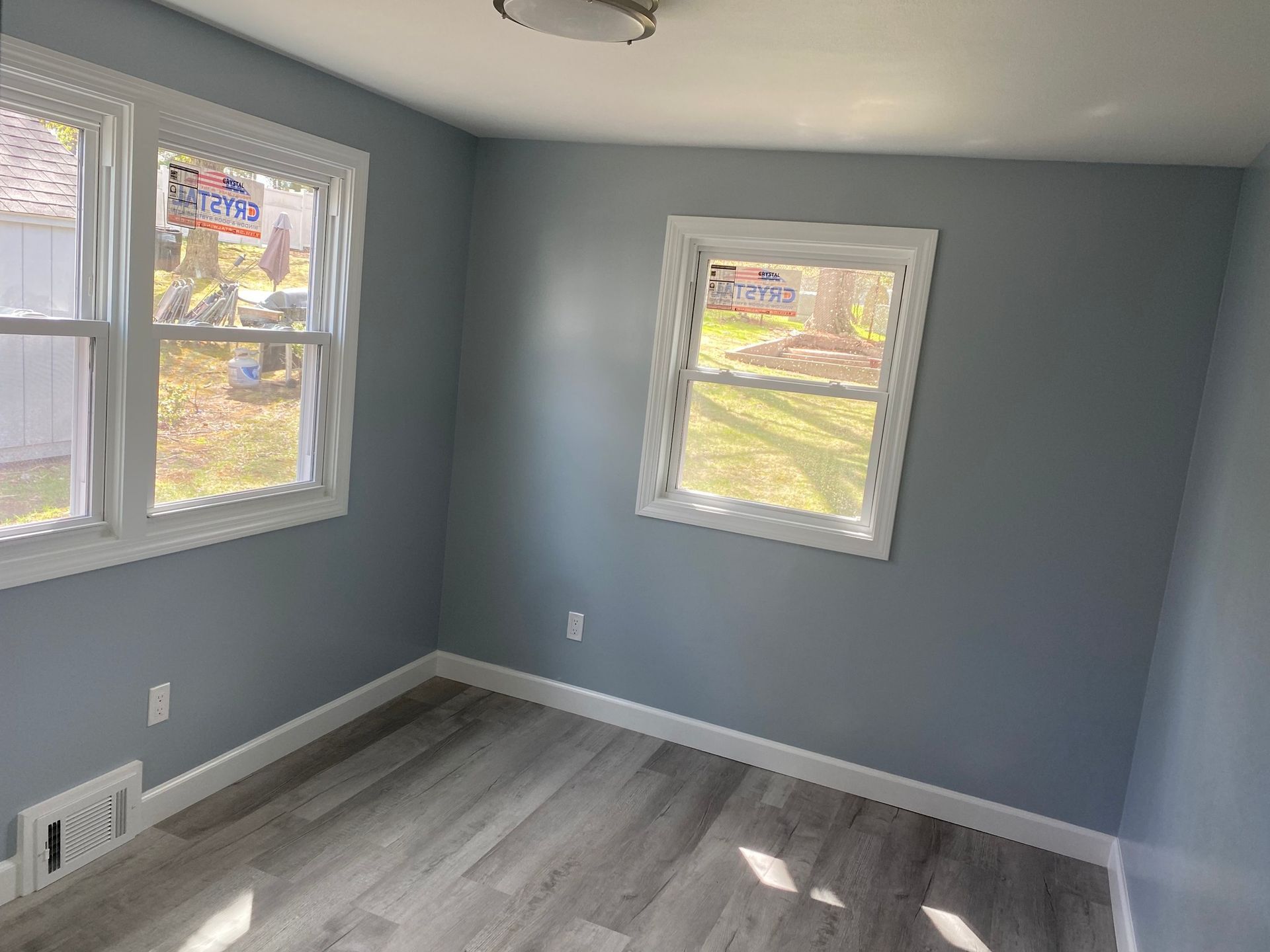 A room with a lot of windows and a wooden floor.