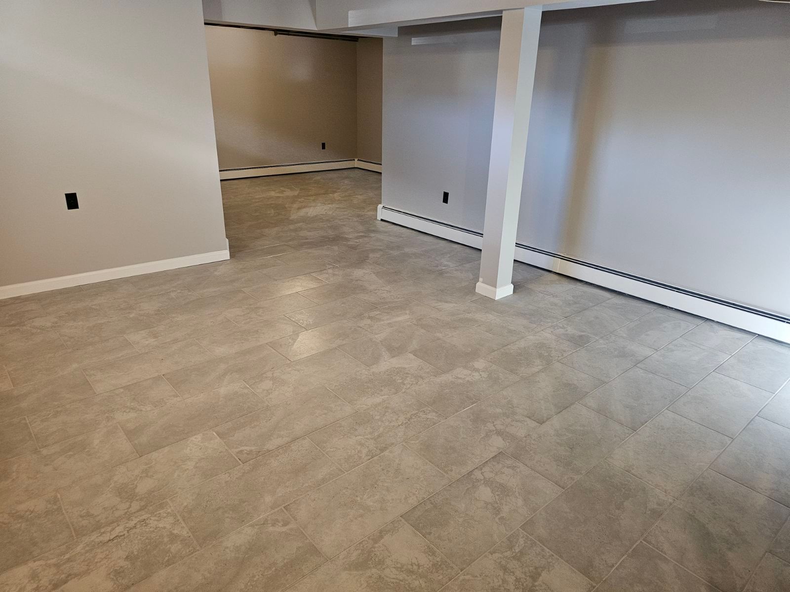 An empty basement with tile floors and white walls.