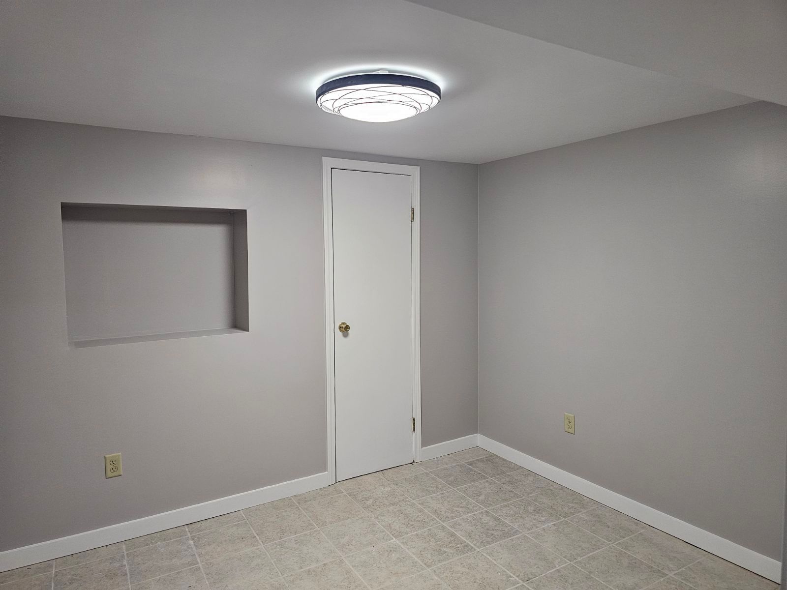 An empty room with a door and a light on the ceiling.