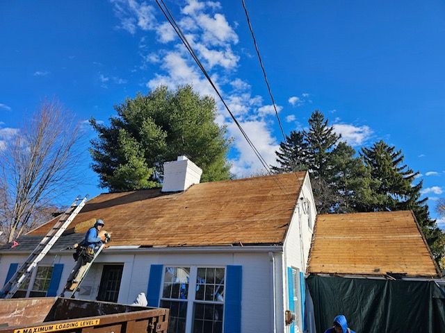 A man is working on the roof of a house.